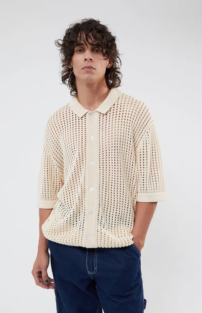 A person wearing a PacSun cream mesh shirt.