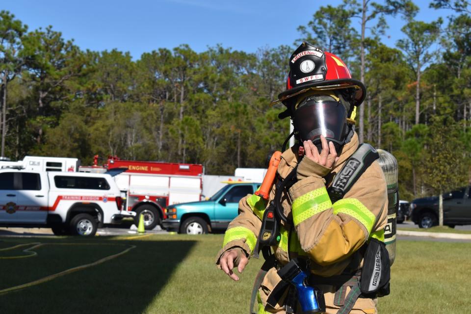 South Walton Fire District Lt. Steve Newsom tightens his face mask during a recent training exercise. Newsom returned to work in December 2020 after a months-long battle with cancer.