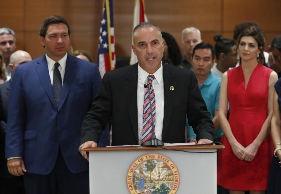 FILE - Andrew Pollack, center, father of Meadow Pollack, who was killed in the Parkland, Fla., school shooting, speaks during a news conference with Florida governor Ron DeSantis, left, Wednesday, Feb. 13, 2019, in Fort Lauderdale, Fla. DeSantis ordered a statewide grand jury investigation on school safety. At right is Florida First Lady Casey DeSantis. (AP Photo/Wilfredo Lee, File)