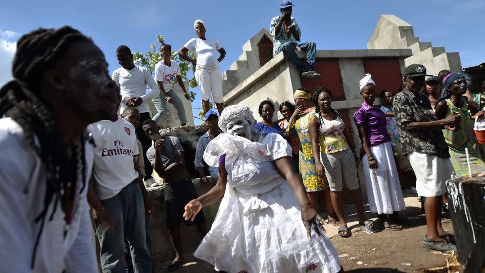 A woman devotee in the role of a spirit known as a Gede is seen during ceremonies honoring the Haitian voodoo spirit of Baron Samdi and Gede on the Day of the Dead in the Cementery of Cite Soleil, in Port-au-Prince, Haiti on November 1, 2017. - Hector Retamal/AFP/Getty Images