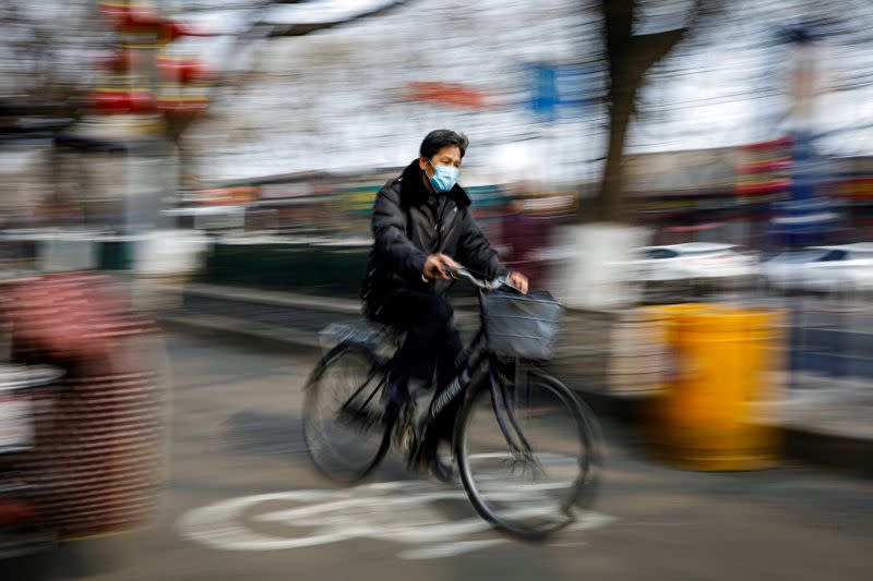 Man wearing a face mask rides a bicycle, as the country is hit by an outbreak of the novel coronavirus, in Beijing