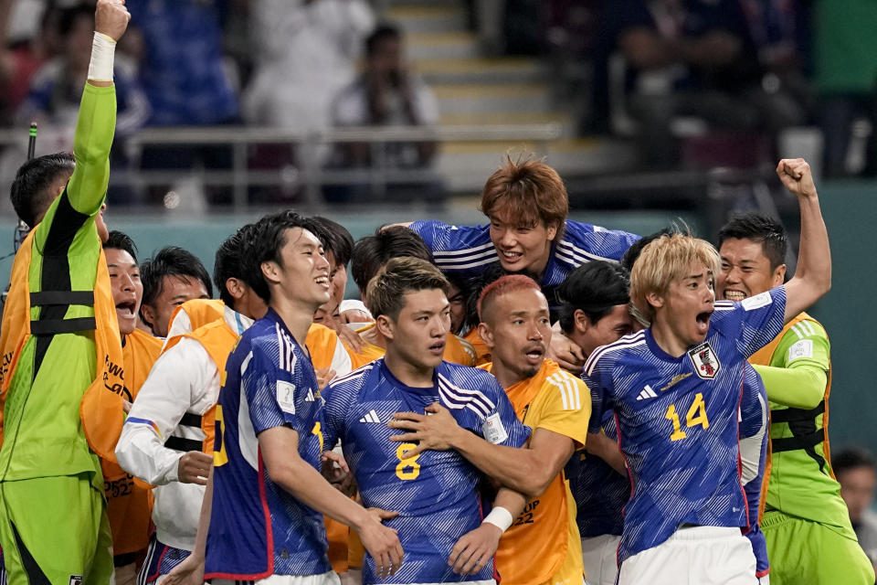 Japan's Ritsu Doan, 8, celebrates scoring his side's first goal with teammates during the World Cup group E soccer match between Germany and Japan, at the Khalifa International Stadium in Doha, Qatar, Wednesday, Nov. 23, 2022. (AP Photo/Ebrahim Noroozi)