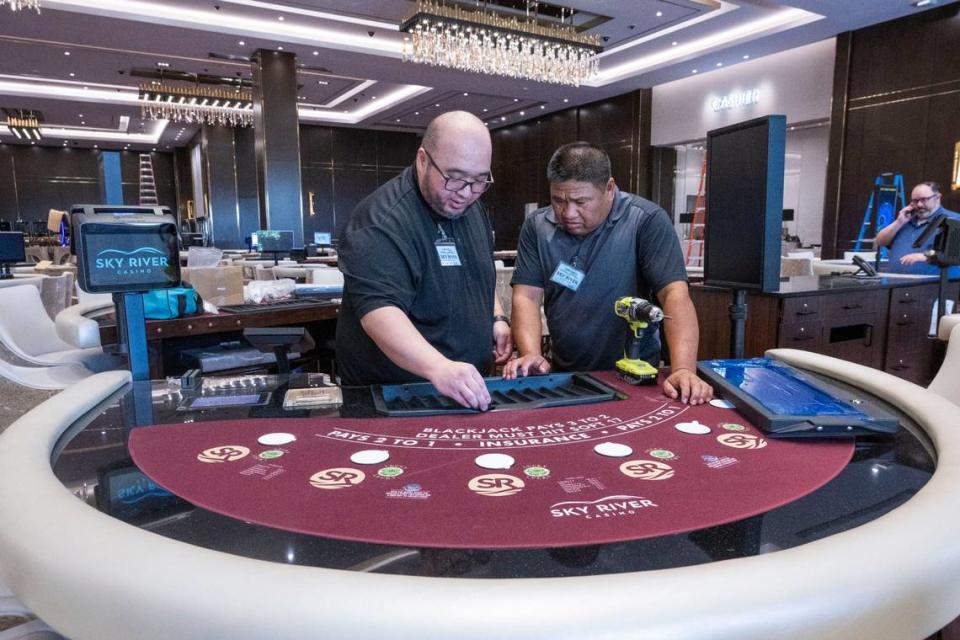 Table games workers Tim Lee, left, and Fred Lacsina work to set up a black jack table on Monday morning at the Sky River Casino in Elk Grove. The casino opened for the first time at 11:30 p.m. that night.