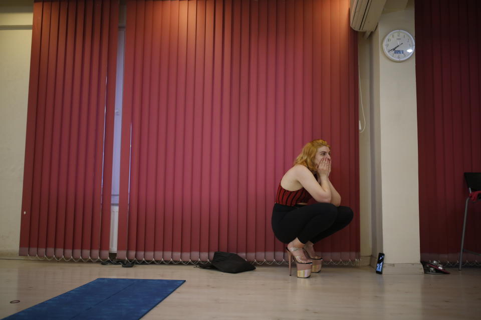 In this Thursday, April 30, 2020 photo, Aybuke Yanar, 21, a pole dancing trainee watches her instructor, Tuba Parlak, a pole dancing performer and instructor giving an online training session to students at home, at her studio in Istanbul. To stem the spread of COVID-19, Turkey closed down sports facilities in March but Parlak's students wanted to continue their pole lessons. Using video conferencing, Parlak teaches the vigorous exercise from her studio in Istanbul's hip Cihangir district. (AP Photo/Emrah Gurel)