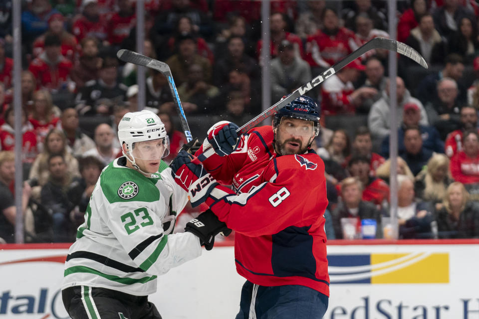 Dallas Stars defenseman Esa Lindell (23) and Washington Capitals left wing Alex Ovechkin (8) look for the puck during the third period of an NHL hockey game, Thursday, Dec. 7, 2023, in Washington. (AP Photo/Stephanie Scarbrough)