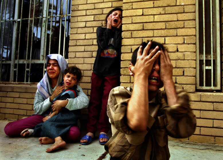 BAGHDAD, IRAQ-April 11, 2003-An Iraqi family grieves in horror at the homecoming of three dead family members shot by U.S. Marines on April 9, 2003. in Baghdad when the men failed to stop their car upon English command. (Carolyn Cole / Los Angeles Times)