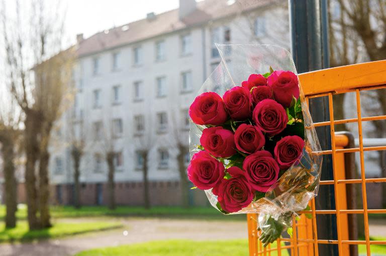 Flowers are attached to a gate outside the building where Chloe -- a nine-year-old girl who was snatched from a playground -- lived in the northern city of Calais