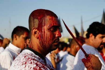 An Iraqi Shi'ite Muslim man gashes his forehead with a sword during a ceremony marking Ashura in Baghdad's Sadr City, Iraq September 20, 2018. REUTERS/Thaier Al-Sudani
