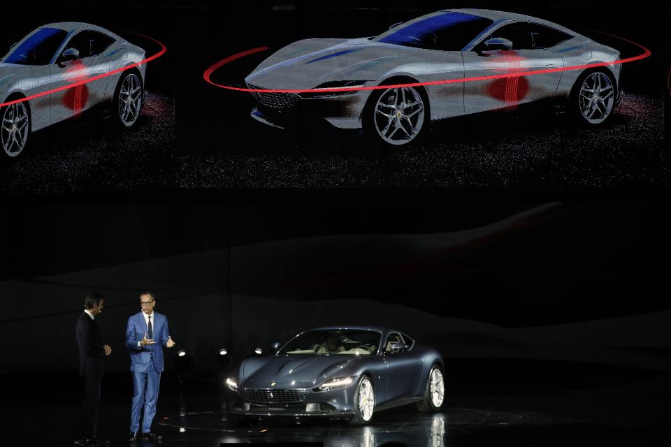 Ferrari Chief Marketing and Commercial Officer, Enrico Galliera, left, and Ferrari design senior vice President, Flavio Manzoni, present the new Ferrari Roma car, in Rome, Thursday, Nov. 14, 2019. Ferrari unveils a new sports coupe aimed at enticing entry-level buyers and competing with the Porsche 911, part of a complete refresh of its model lineup by 2022. (AP Photo/Gregorio Borgia)