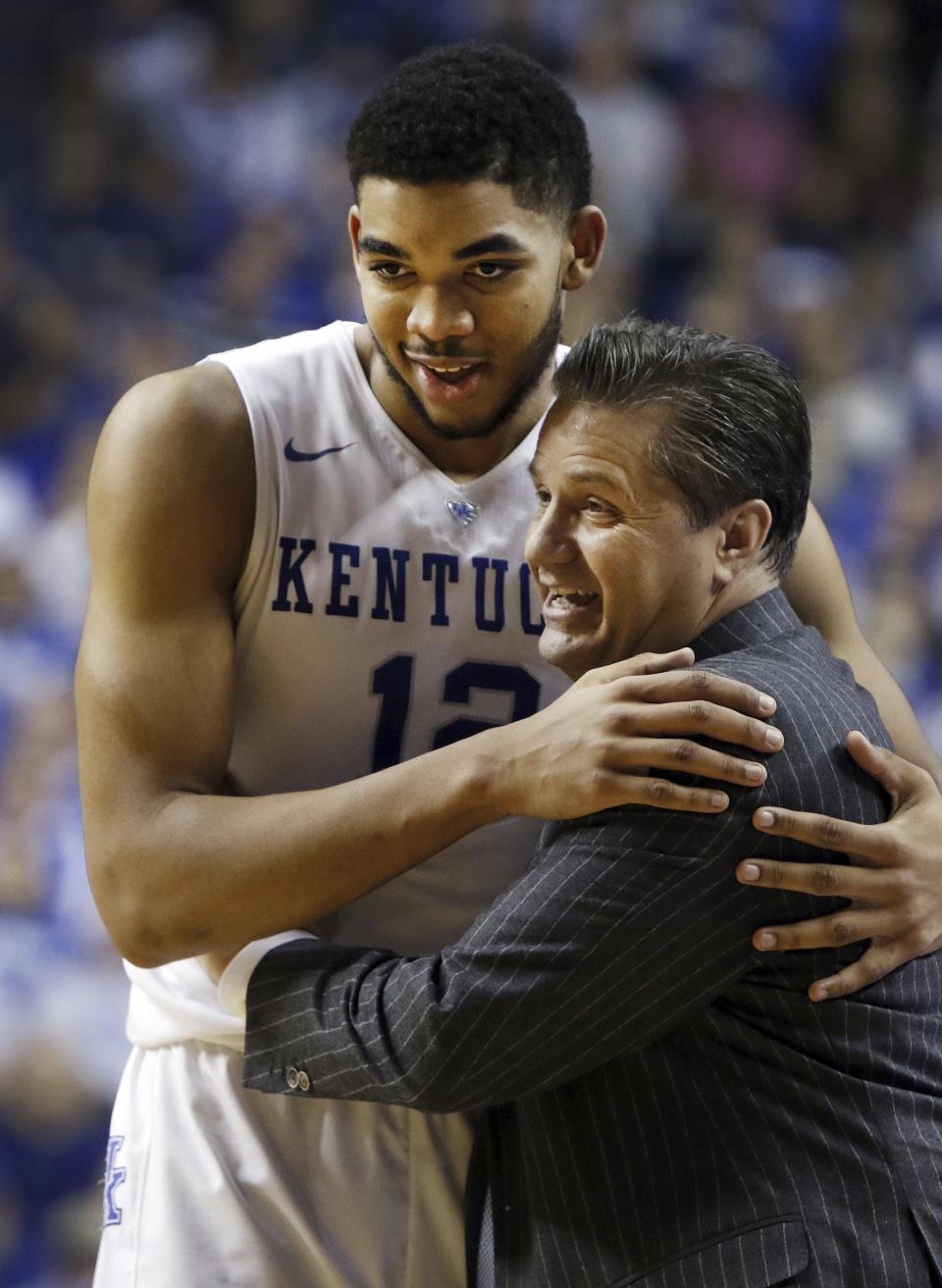 FILE - Kentucky's Karl-Anthony Towns, left, gets a hug from head coach John Calipari during the second half of an NCAA college basketball game against Georgia, Tuesday, Feb. 3, 2015, in Lexington, Ky. Kentucky won 69-58. (AP Photo/James Crisp, File)