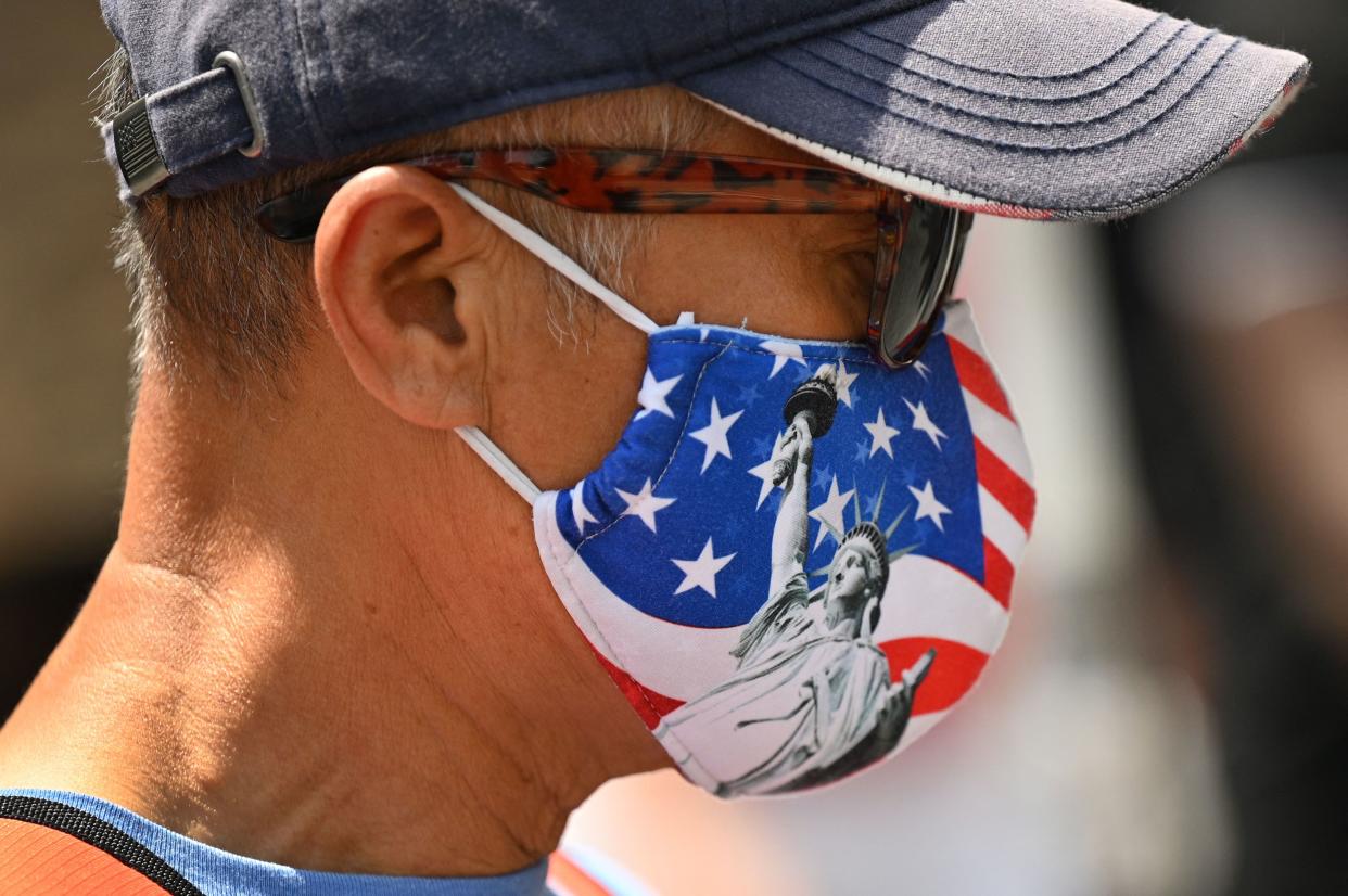 A man wears an American flag mask with a print of the Statue of Liberty in Los Angeles, California, August 18, 2021. - Los Angeles County issued a revised Covid-19 health ordinance on August 17, requiring protective masks to be worn at outdoor 