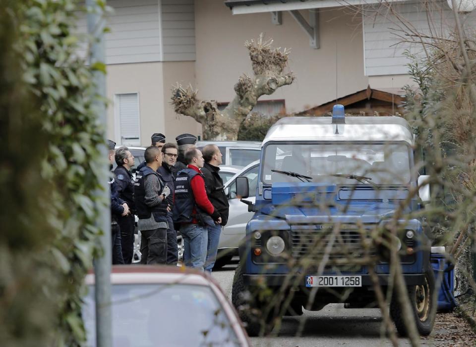 French police investigators stand outside a house in a residential area in Talloires, French Alps, Tuesday, Feb. 18, 2014, as part of an investigation into the grisly shooting deaths of a British-Iraqi man and three others nearly 18-months ago. French police announced Tuesday they have detained a 48-year old man, a resident of eastern France, in connection with the deaths. (AP Photo/Laurent Cipriani)