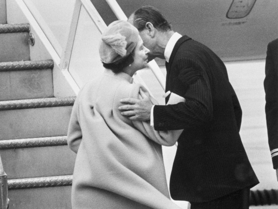 Prince Philip kisses Queen Elizabeth before she boards a plane