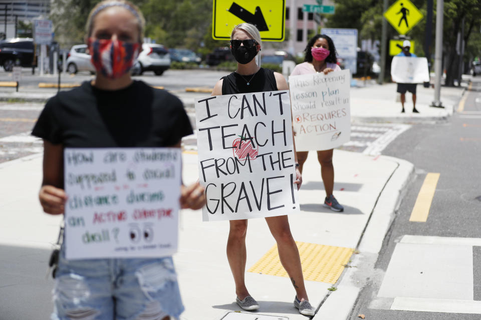 TAMPA, FL - JULY 16: Middle school teacher Brittany Myers, (C) stands in protest in front of the Hillsborough County Schools District Office on July 16, 2020 in Tampa, Florida. Teachers and administrators from Hillsborough County Schools rallied against the reopening of schools due to health and safety concerns amid the COVID-19 pandemic. (Photo by Octavio Jones/Getty Images)