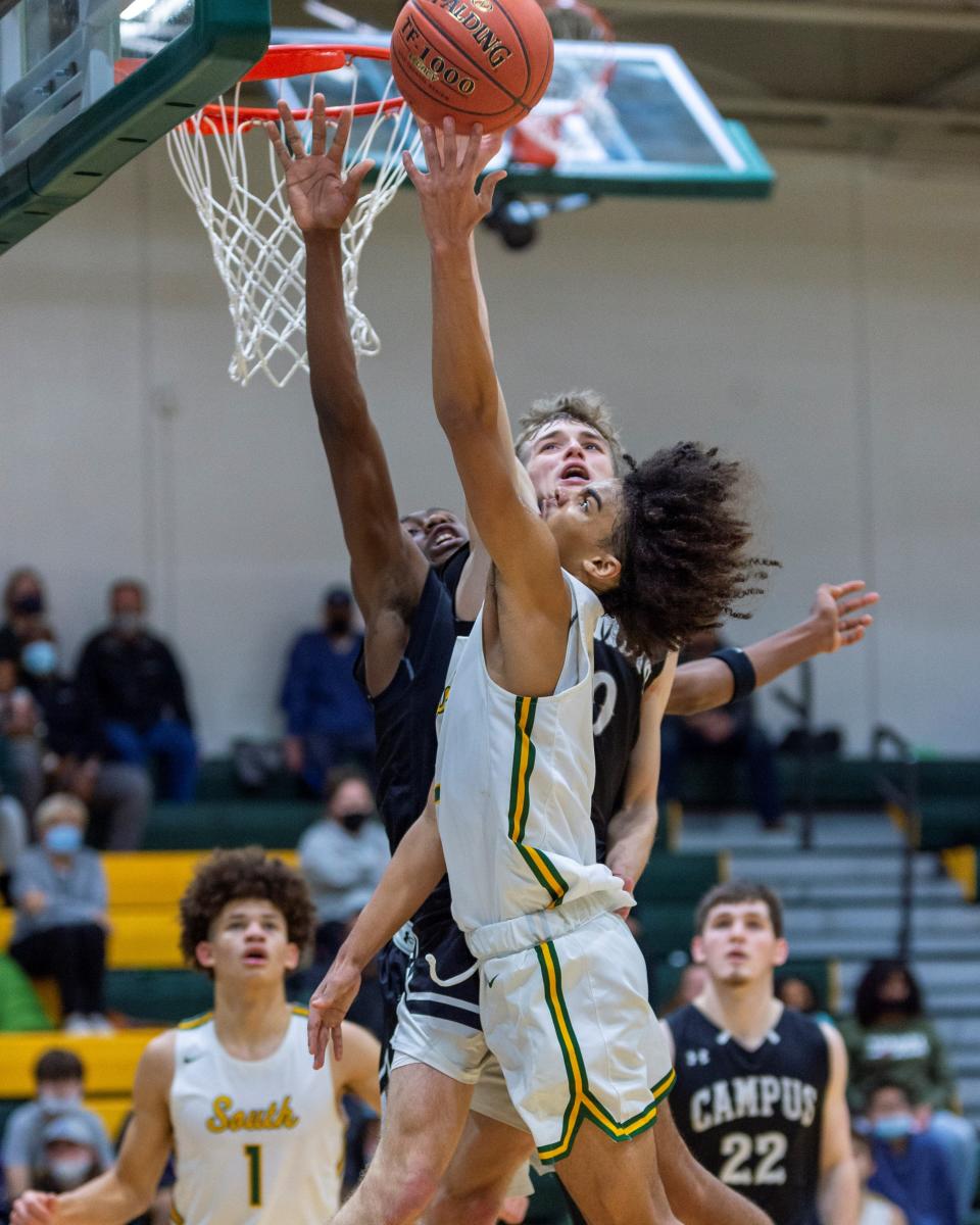 Salina South's Devin Myers lays the ball up over two Campus defenders in Friday night's game at the South gym.