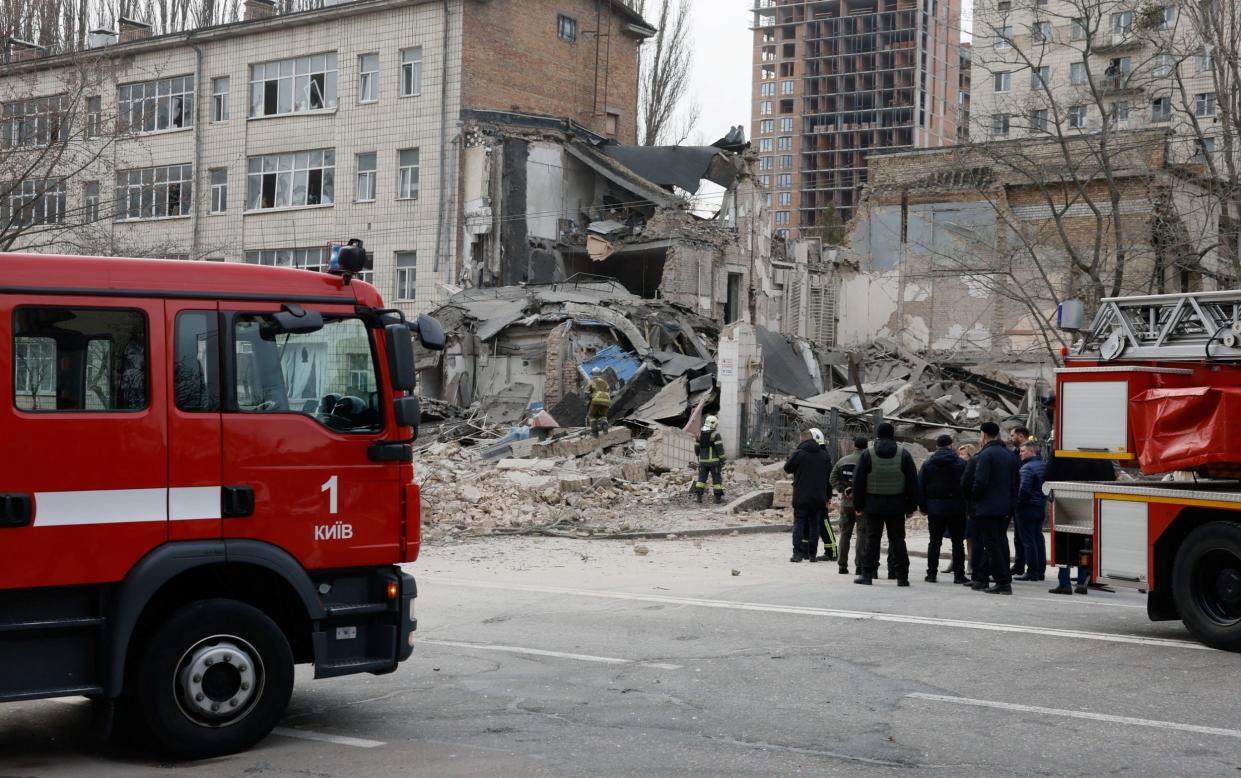 Rescuers work at the site of a building damaged by a Russian missile strike