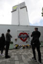 People mourn at the Grenfell tower to mark the two-year anniversary of the Grenfell Tower block fire in London, Friday, June 14, 2019. Survivors, neighbors and politicians including London Mayor Sadiq Khan attended a church service of remembrance on Friday for the Grenfell Tower blaze, the deadliest fire on British soil since World War II. (AP Photo/Frank Augstein)