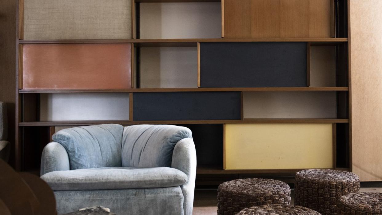 a room with a couch and a shelf with books