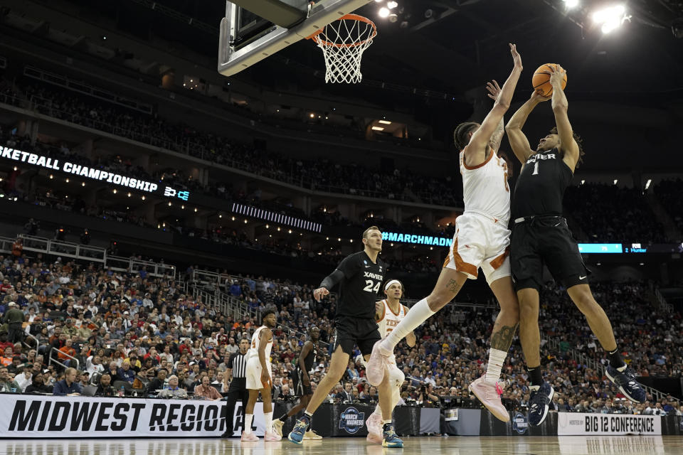 Xavier guard Desmond Claude shoots over Texas forward Timmy Allen in the first half of a Sweet 16 college basketball game in the Midwest Regional of the NCAA Tournament Friday, March 24, 2023, in Kansas City, Mo. (AP Photo/Charlie Riedel)