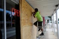 FILE PHOTO: A man boards up a business ahead of the arrival of Hurricane Dorian in Cocoa
