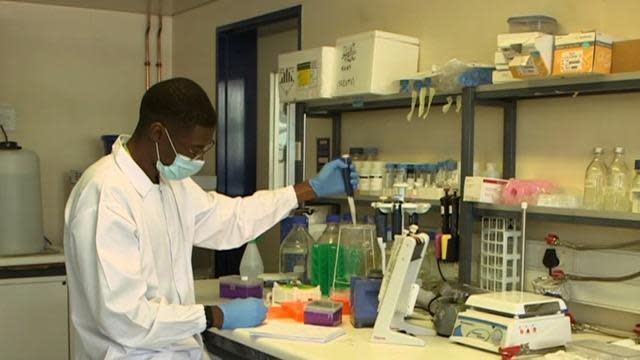 A researcher investigating the new strain of the COVID-19 virus discovered in South Africa works at a lab in Durban. / Credit: CBS News