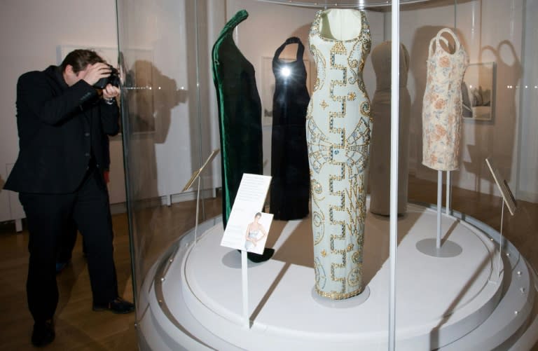 A photographer takes pictures of dresses worn by Britain's Diana, Princess of Wales, during a preview of the forthcoming exhibition entitled "Diana: Her Fashion Story", at Kensington Palace in London on February 22, 2017