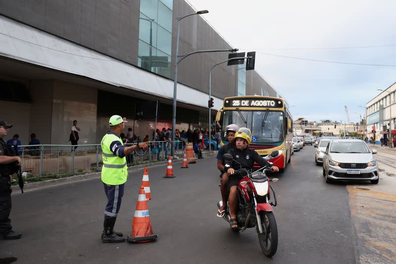 Police officers direct traffic outside the bus terminal station after a man hijacked a bus with passengers, in Rio de Janeiro