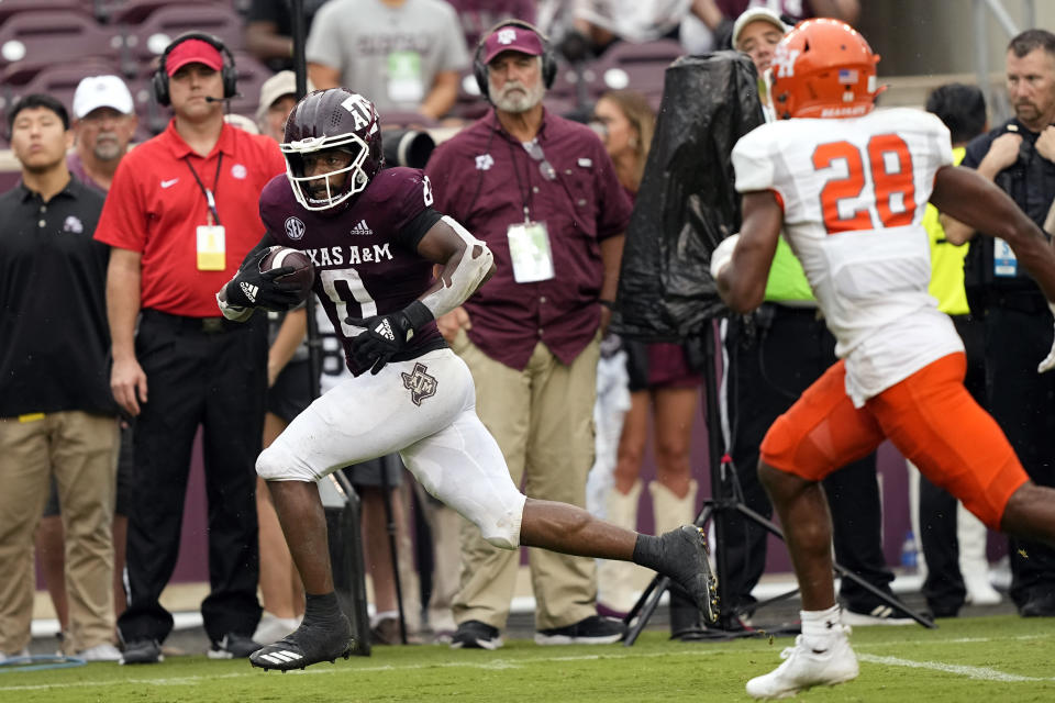 Texas A&M wide receiver Ainias Smith (0) runs down the sideline after catching a pass to score a touchdown as Sam Houston State defensive back Jaidan Scott (28) defends during the second half of an NCAA college football game Saturday, Sept. 3, 2022, in College Station, Texas. (AP Photo/David J. Phillip)
