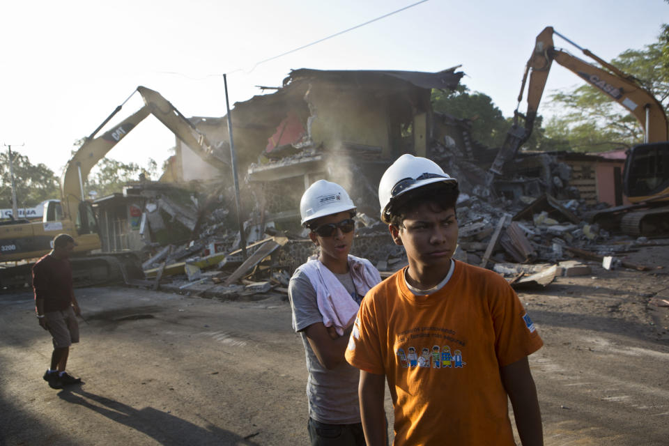 Young members of the Civil Defense work at the site of a building demolition after earthquakes affected Managua, Nicaragua, Monday, April 14, 2014. The building had been previously damaged by an earthquake in 1972, and demolished today after several more recent earthquakes. People who had been living in earthquake damaged buildings were ordered to evacuate after several quakes have affected Nicaragua since Thursday. (AP Photo/Esteban Felix)