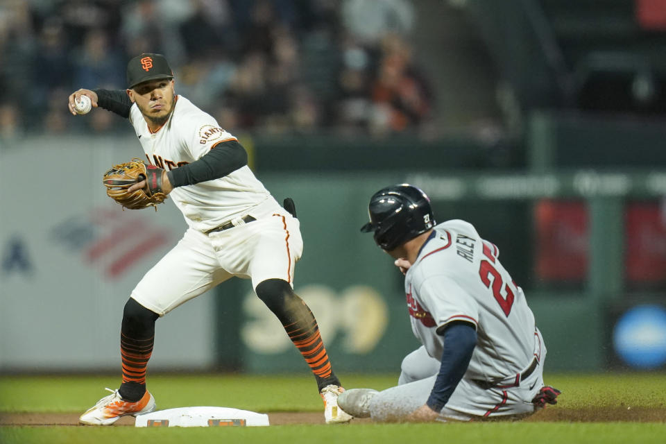 San Francisco Giants second baseman Thairo Estrada, left, throws to first to turn a double play as Atlanta Braves' Austin Riley slides at second during the fourth inning of a baseball game in San Francisco, Monday, Sept. 12, 2022. (AP Photo/Godofredo A. Vásquez)