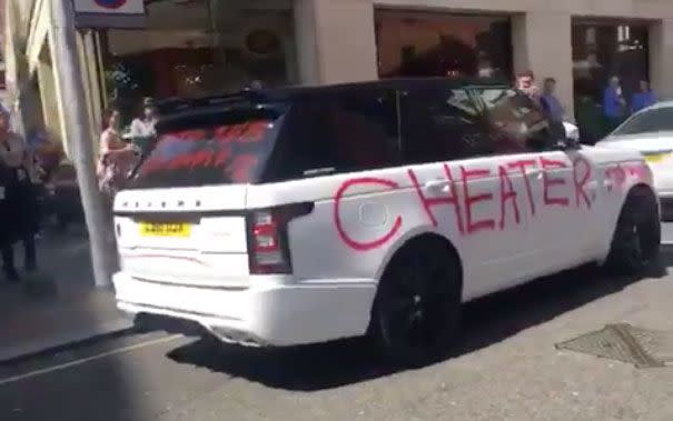 The alleged love rat sped off in his car as crowds of bystander's snapped pictures of the defacing. Photo: Twitter/BanditCab