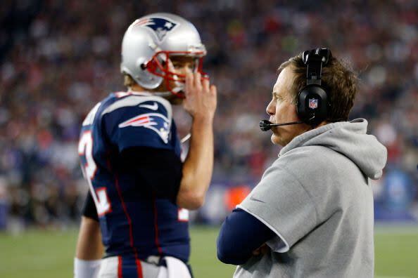 FOXBORO, MA - JANUARY 13:  Tom Brady #12 of the New England Patriots wlaks past head coach Bill Belichick of the New England Patriots against the Houston Texans during the 2013 AFC Divisional Playoffs game at Gillette Stadium on January 13, 2013 in Foxboro, Massachusetts.  (Photo by Jim Rogash/Getty Images)
