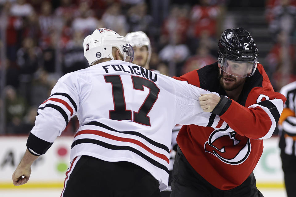 New Jersey Devils defenseman Brendan Smith (2) fights with Chicago Blackhawks left wing Nick Foligno during the second period of an NHL hockey game Friday, Jan. 5, 2024, in Newark, N.J. The Devils won 4-2. (AP Photo/Adam Hunger)