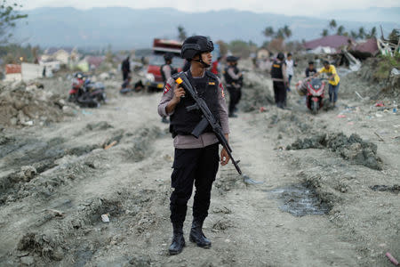 A member of the Indonesian special operations Mobile Brigade Corps patrols Petobo neighborhood hit by the earthquake and liquefaction in Palu, Central Sulawesi, Indonesia, October 11, 2018. REUTERS/Jorge Silva