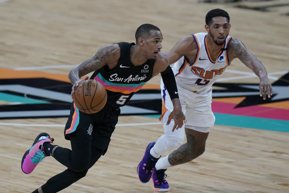 San Antonio Spurs guard Dejounte Murray (5) drives around Phoenix Suns guard Cameron Payne (15) during the second half of an NBA basketball game in San Antonio, Sunday, May 16, 2021. (AP Photo/Eric Gay)