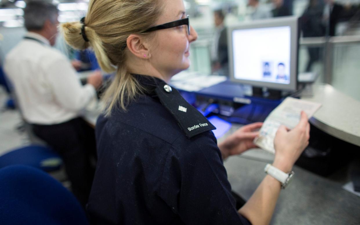 Border Force officers check the passports of passengers arriving at Gatwick Airport - Oli Scarff /Getty Images