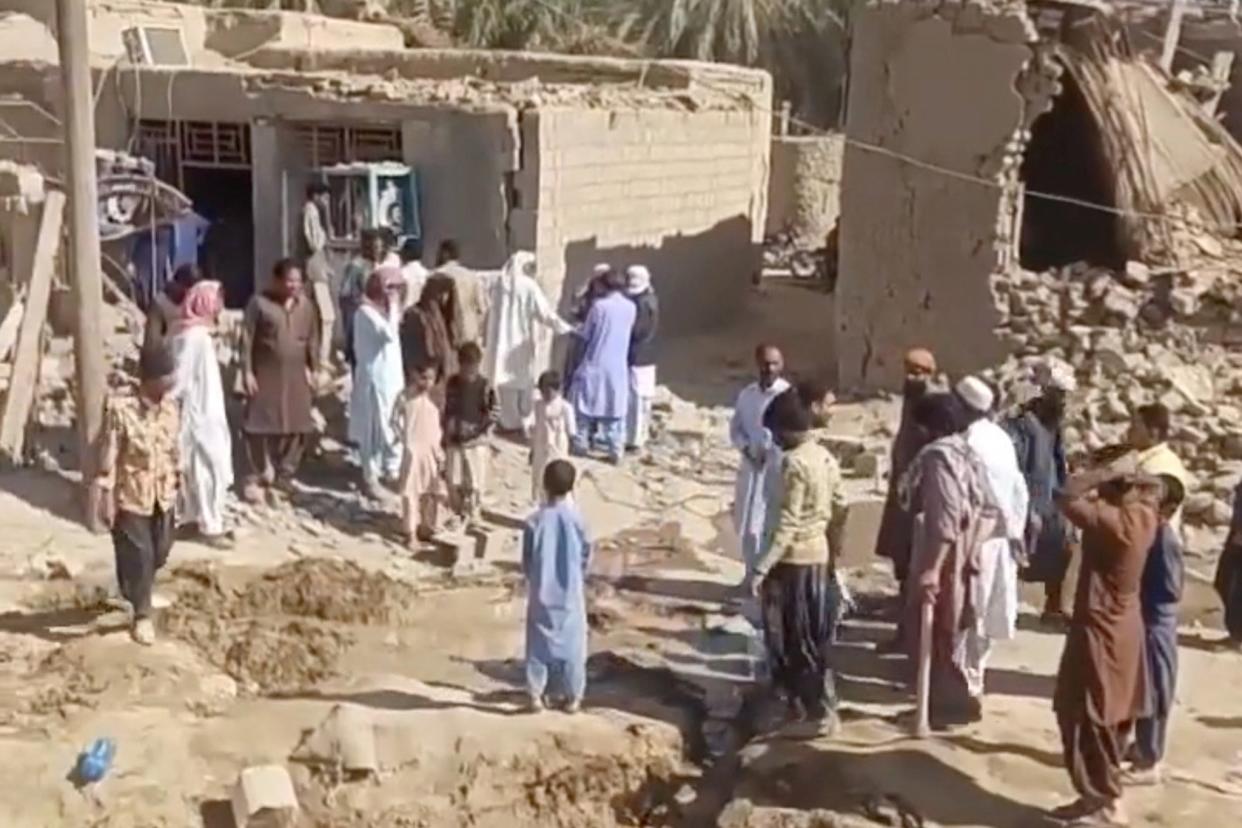 People gather near rubble in the aftermath of Pakistan's military strike on an Iranian village near Saravan, Sistan and Baluchestan Province, Iran, January 18 (via REUTERS)