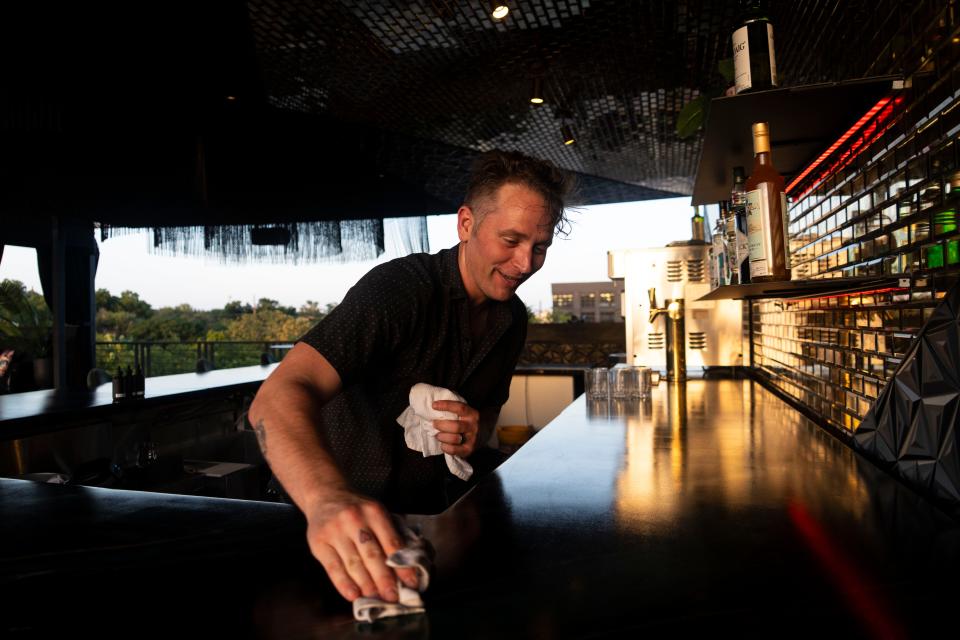 Patrick Gartner, general manager of bars at Inn Cahoots, wipes down the counter at its rooftop bar, IYKYK.