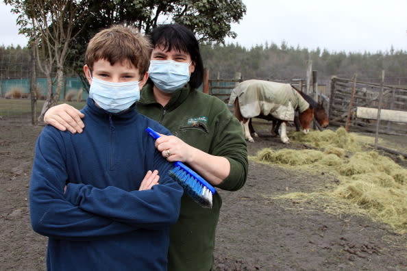 Josh Martin, 14, and mother Karen Martin pose while cleaning up a friends' property after Mt Tongariro erupted for the first time in over 100 years on August 7, 2012 in Tongariro National Park, New Zealand. Mt Tongariro erupted intermittently from 1855 to 1897. Although not an immediate threat to the community, the latest eruption may be the beginning of weeks, months or even years of volcanic activity. (Photo by Hagen Hopkins/Getty Images)