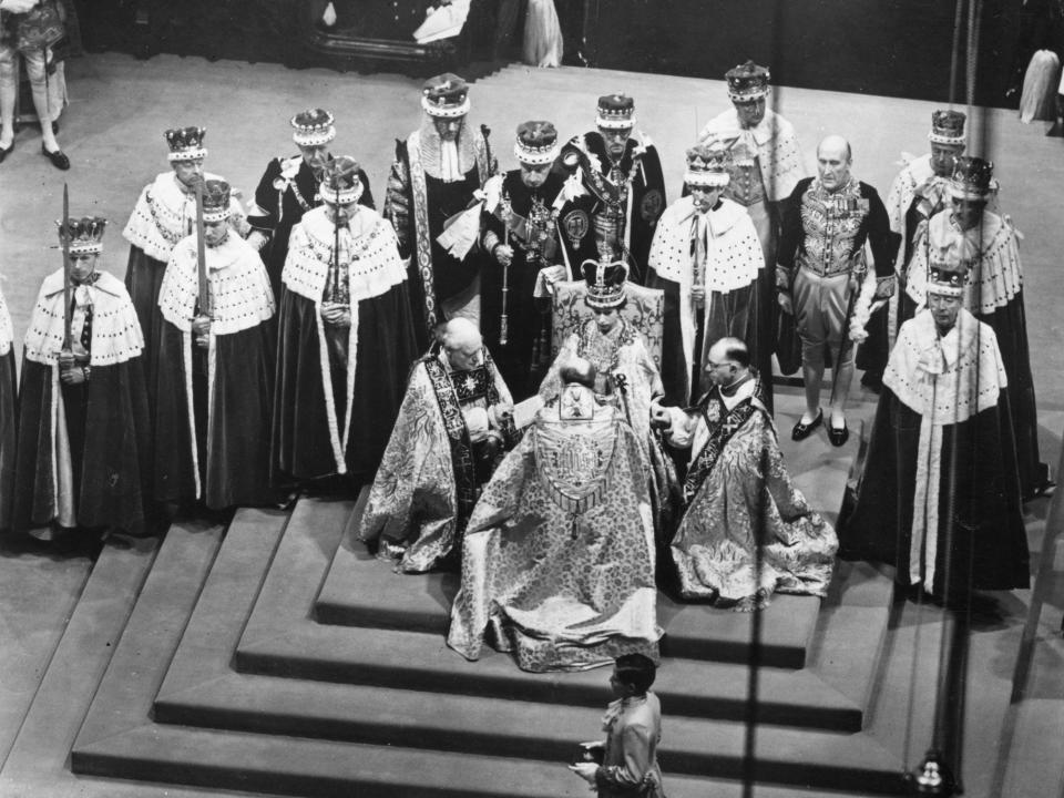 Queen Elizabeth sits in a throne during her coronation at Westminster Abbey.