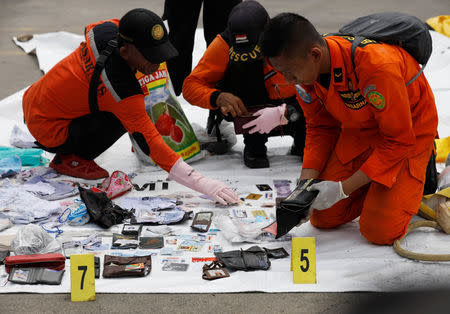 Rescue workers lay out recovered belongings believed to be from the crashed Lion Air flight JT610 at Tanjung Priok port in Jakarta, Indonesia, October 30, 2018. REUTERS/Edgar Su