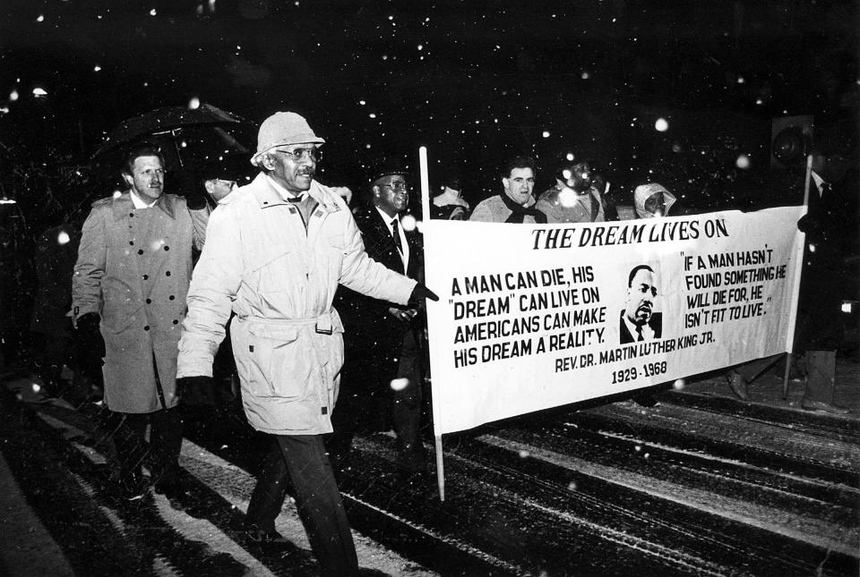 The Central United Methodist Church held a march commemorating Dr. Martin Luther King, Jr. December 1969. Leading the way were Richard Frank, foreground, David Ashe, holding umbrella, and Mayor Louis LaPolla.