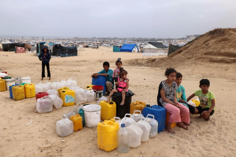 Displaced Palestinian children wait for water at their tent camp in Rafah -- the UN children's agency estimates the war has displaced around 850,000 children in Gaza (MOHAMMED ABED)