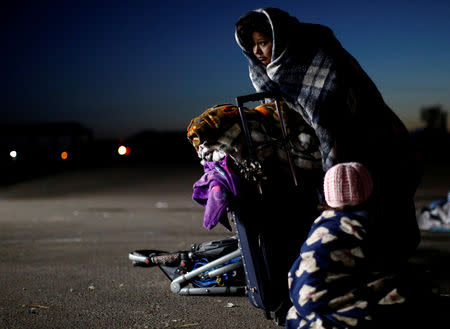 A migrant woman and her daughter from Honduras, part of a caravan of thousands traveling from Central America to the United States, prepare to get on a bus bound for Mexicali at a makeshift camp in Navojoa, Mexico November 17, 2018. REUTERS/Kim Kyung-Hoon