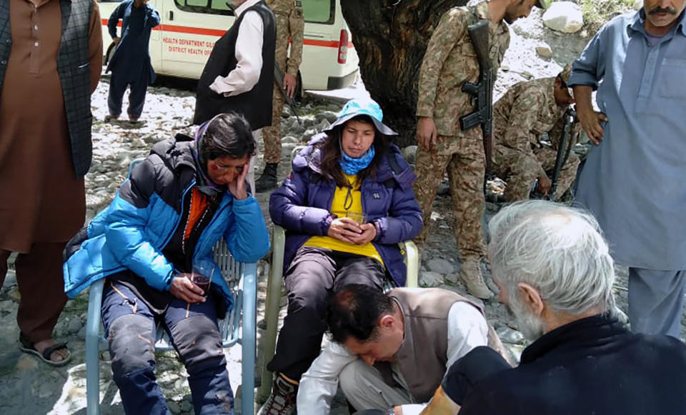 In this photo provided by Gilgit Baltistan regional police department, mountaineers receive initial treatment following their rescue, at a helipad in the town of Imit, Ghizer district of Gilgit Balistan region, Pakistan, Tuesday, Jun 18, 2019. A Pakistani army helicopter rescued on Tuesday four Italian and two Pakistani climbers stranded at an altitude of around 5,300 meters (17,390 feet) in the country's north, after an avalanche struck the team the previous day, a mountaineering worker said. A Pakistani member of the team was killed. (Gilgit Baltistan regional police department via AP)