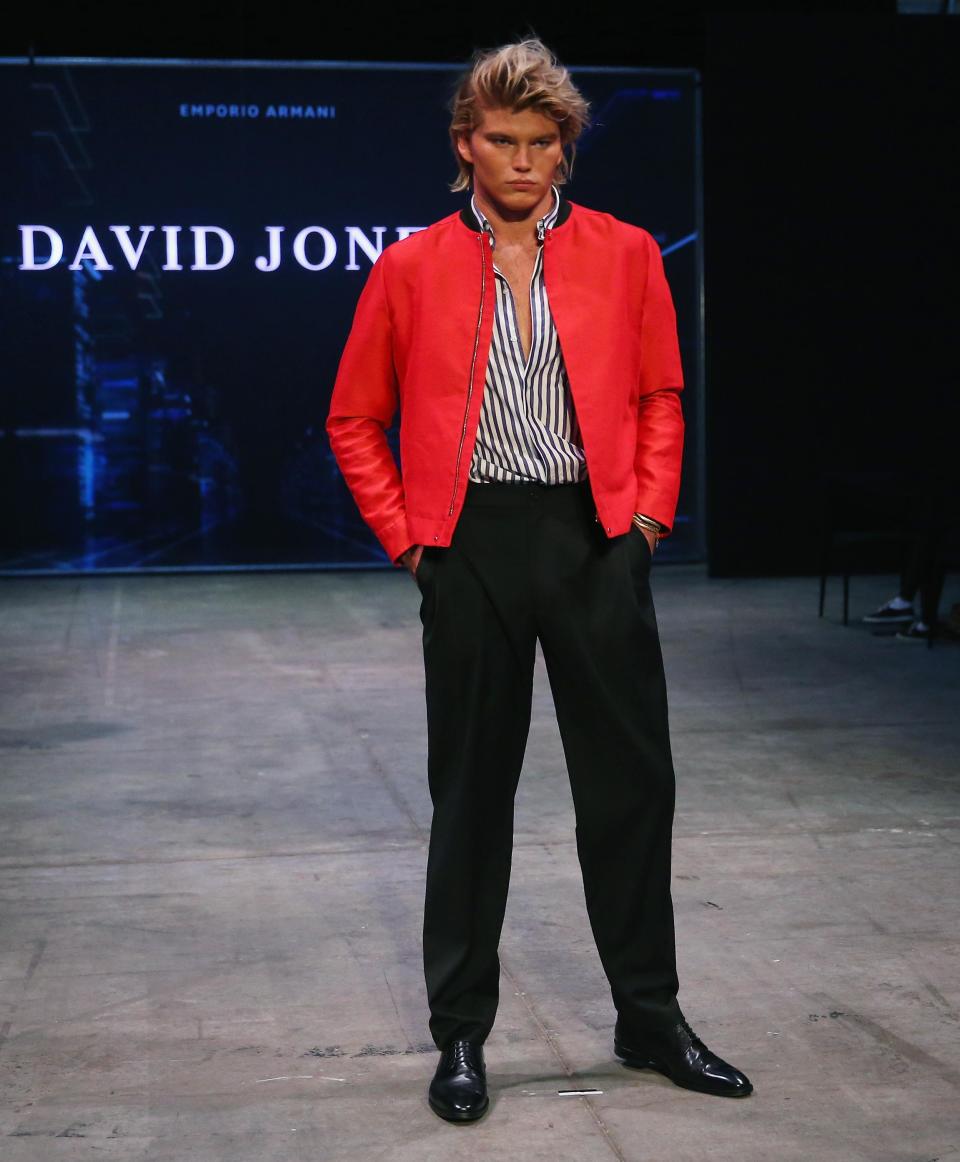 <p>Male model Jordan looks striking in a black and white striped shirt and a bright red jacket.</p>