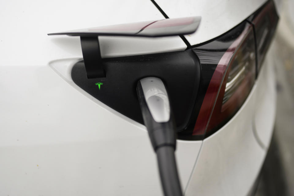 Tesla's EV charging connector is plugged into an electric vehicle at a charging station in Anaheim, Calif., Friday, June 9, 2023. Owners of General Motors and Ford electric vehicles will be able charge at many of Tesla's large network of stations across the U.S. starting next year. (AP Photo/Jae C. Hong)