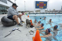 U.S. Olympic Water Polo Men's head coach Dejan Udovicic, sitting left, talks to the team during a training session for the Paris Olympics, at Mt. San Antonio College in Walnut, Calif., on Wednesday, Jan. 17, 2024. (AP Photo/Damian Dovarganes)