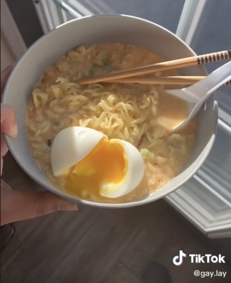 A bowl of creamy ramen with a soft-boiled egg