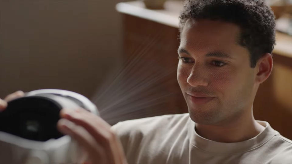 A man scanning his face with the Apple Vision Pro headset